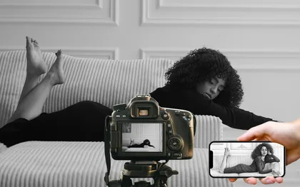 A woman lying on a couch photographed in black and white with a camera and a smartphone
